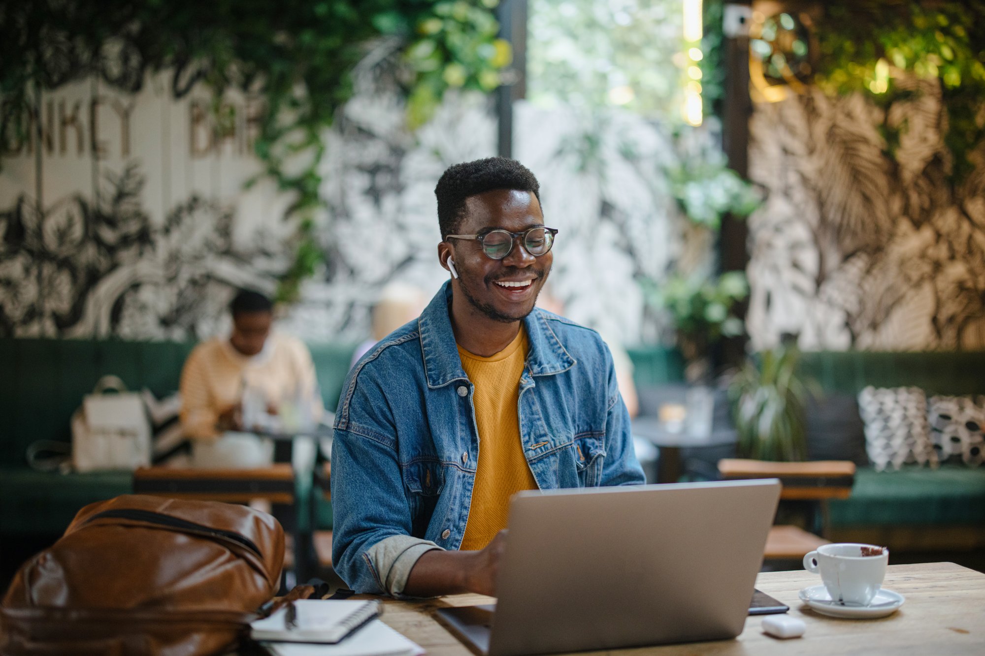 Male student working on his laptop in a cafe